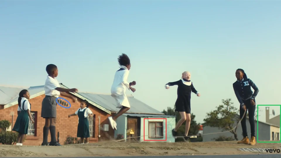 Children playing skipping rope outside a residential building on Sofasonke Street in Soweto in Makeba music video at 0:54