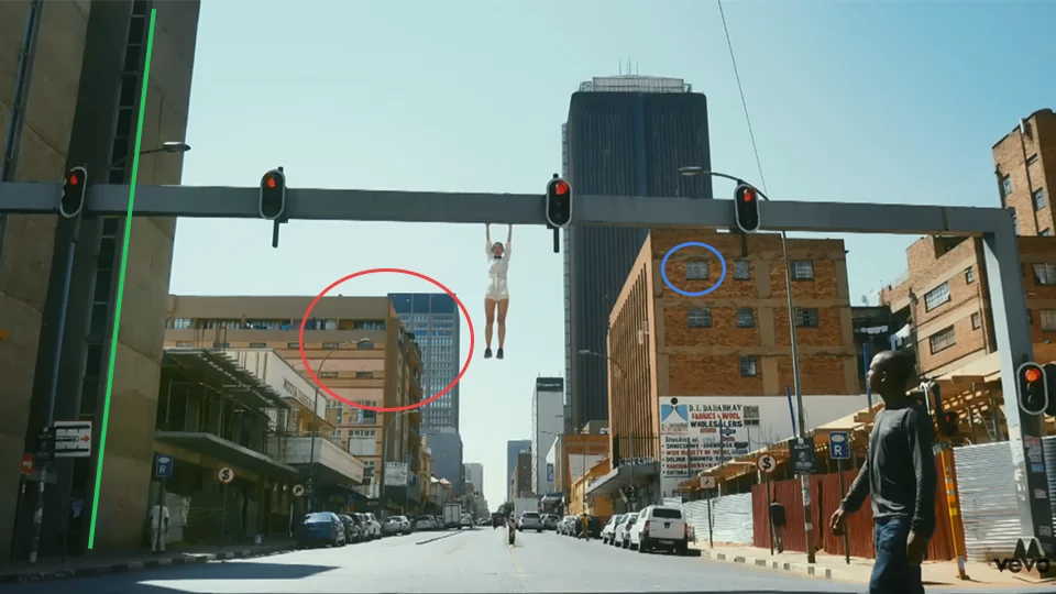 Jain hanging from a traffic light gantry above Albertina Sisulu Road in Johannesburg in Makeba music video at 2:34